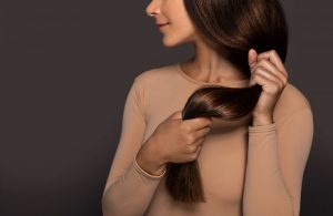 woman holding her brown hair